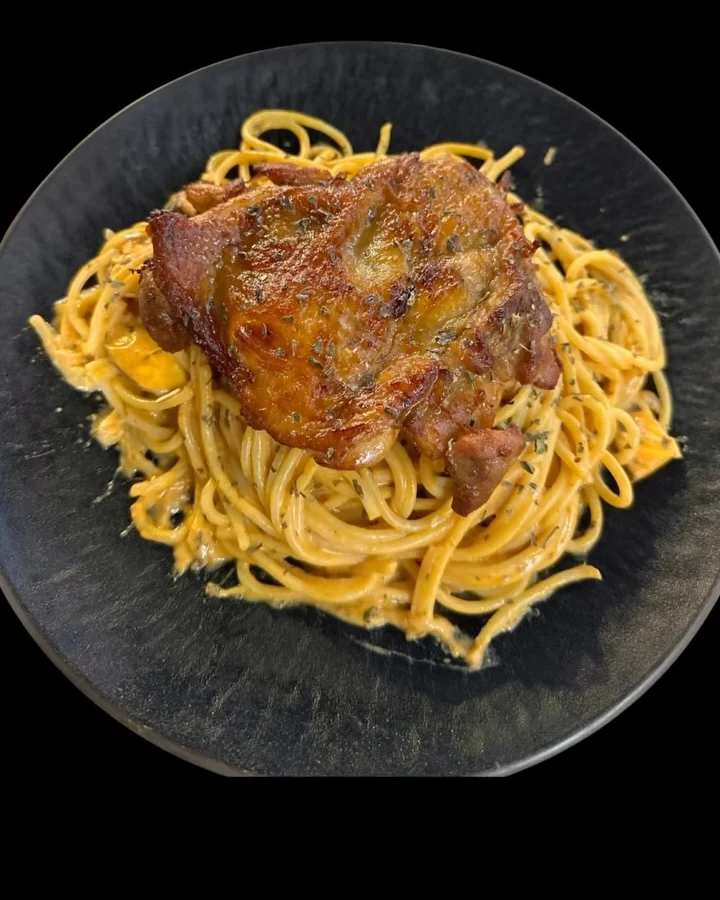 Spaghetti topped with a grilled chicken chop