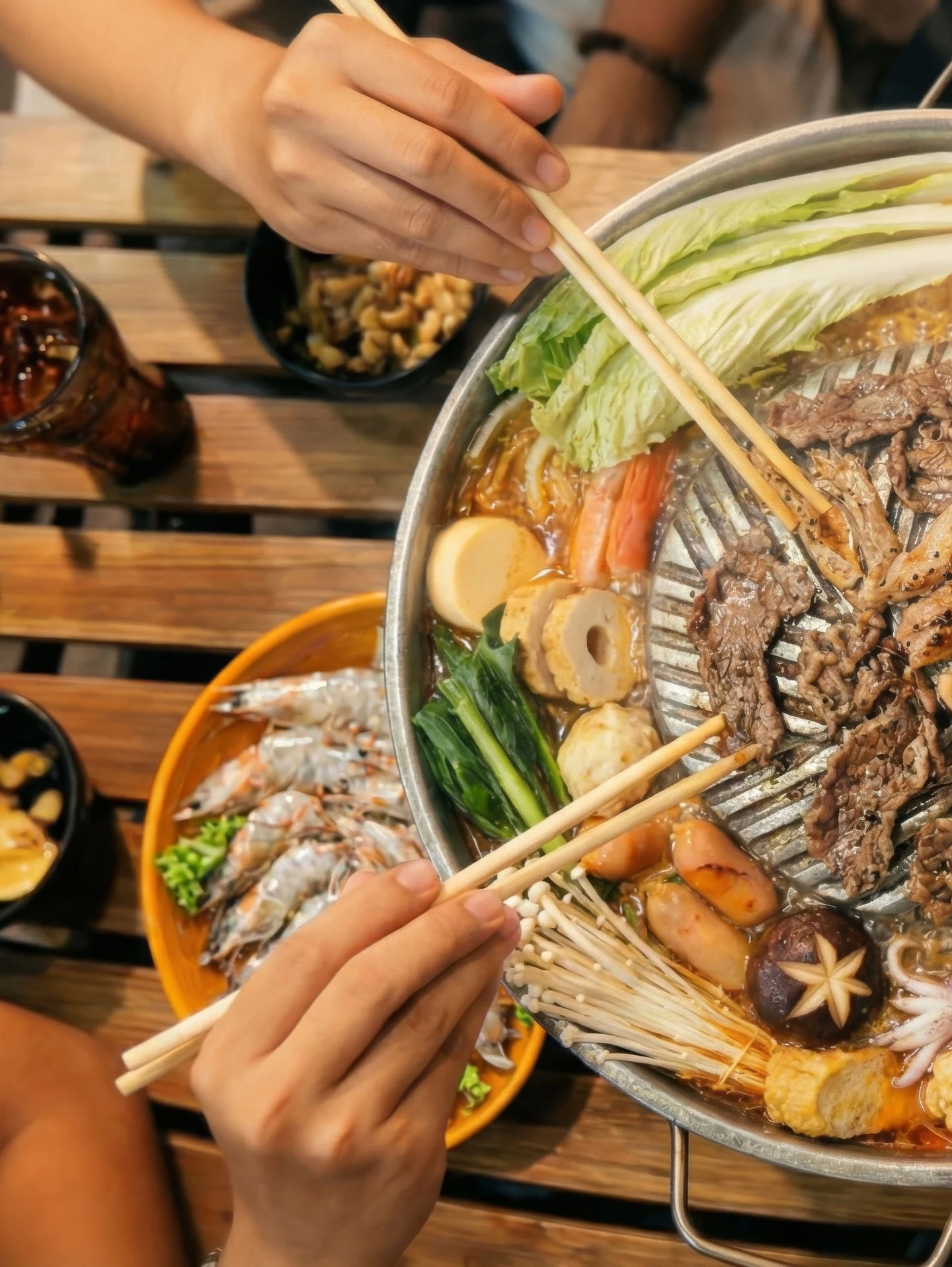 Chopsticks pulling beef and fishballs from a Steambro steamboat